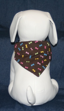 Stuffed Dog Modeling Multi-colored Bones on Chocolate Bandana